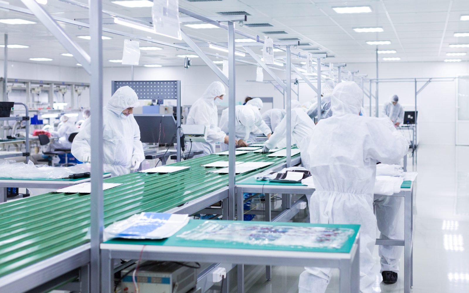 people in white isolating costumes working in laboratory